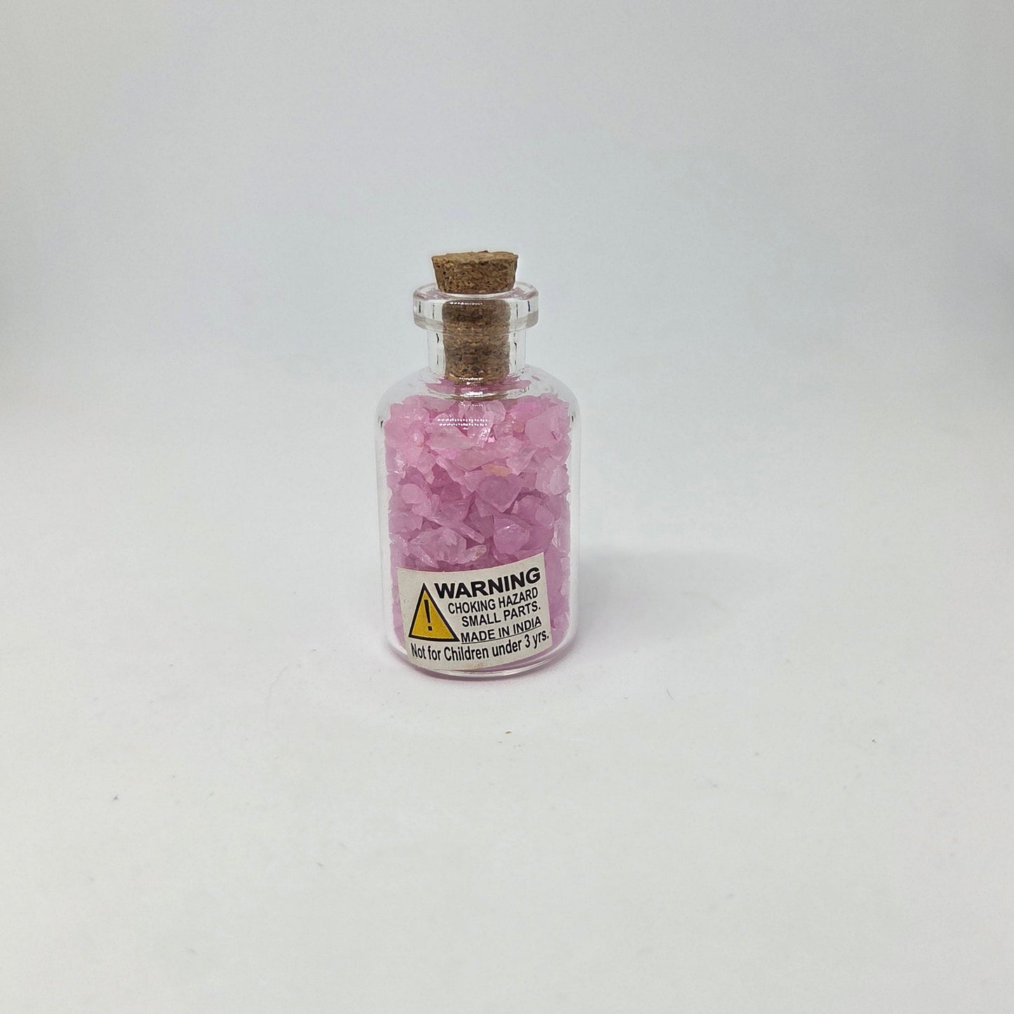 Small glass bottle with pink contents on a white background