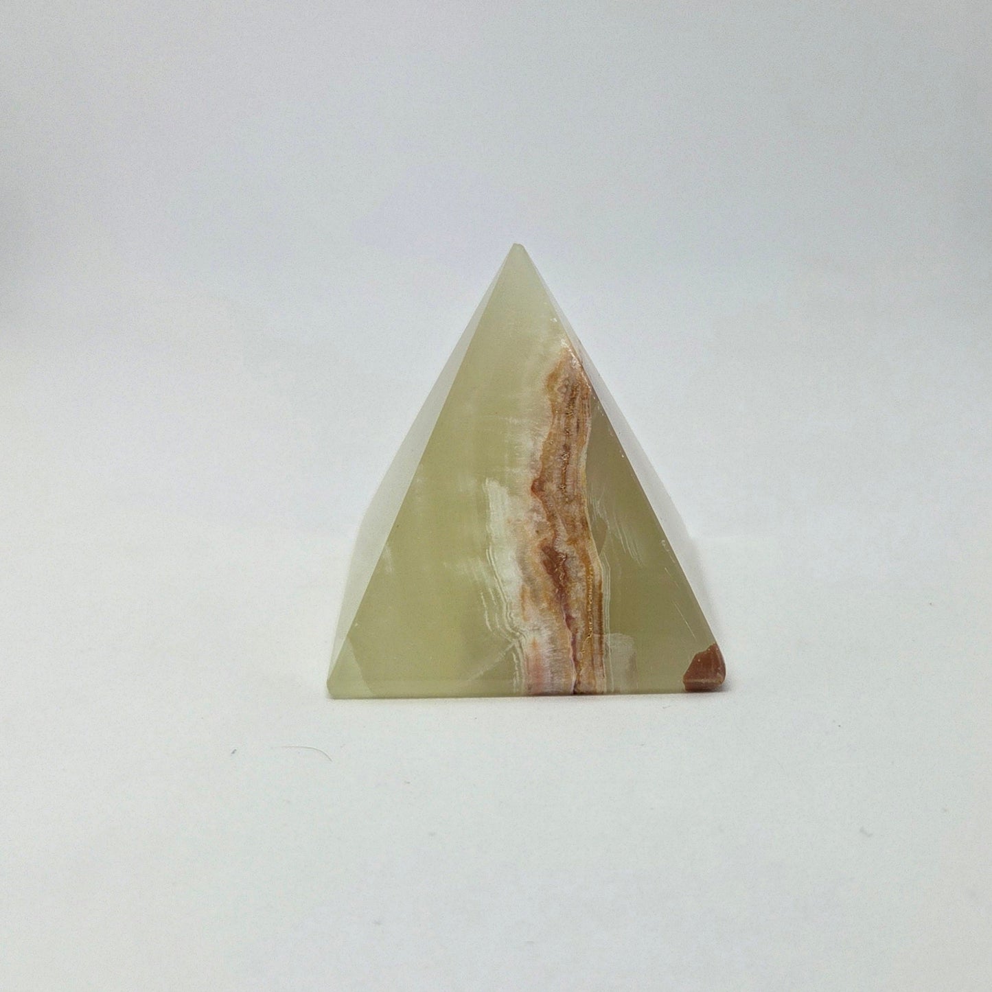 Triangular stone with brown and white patterns on a white background