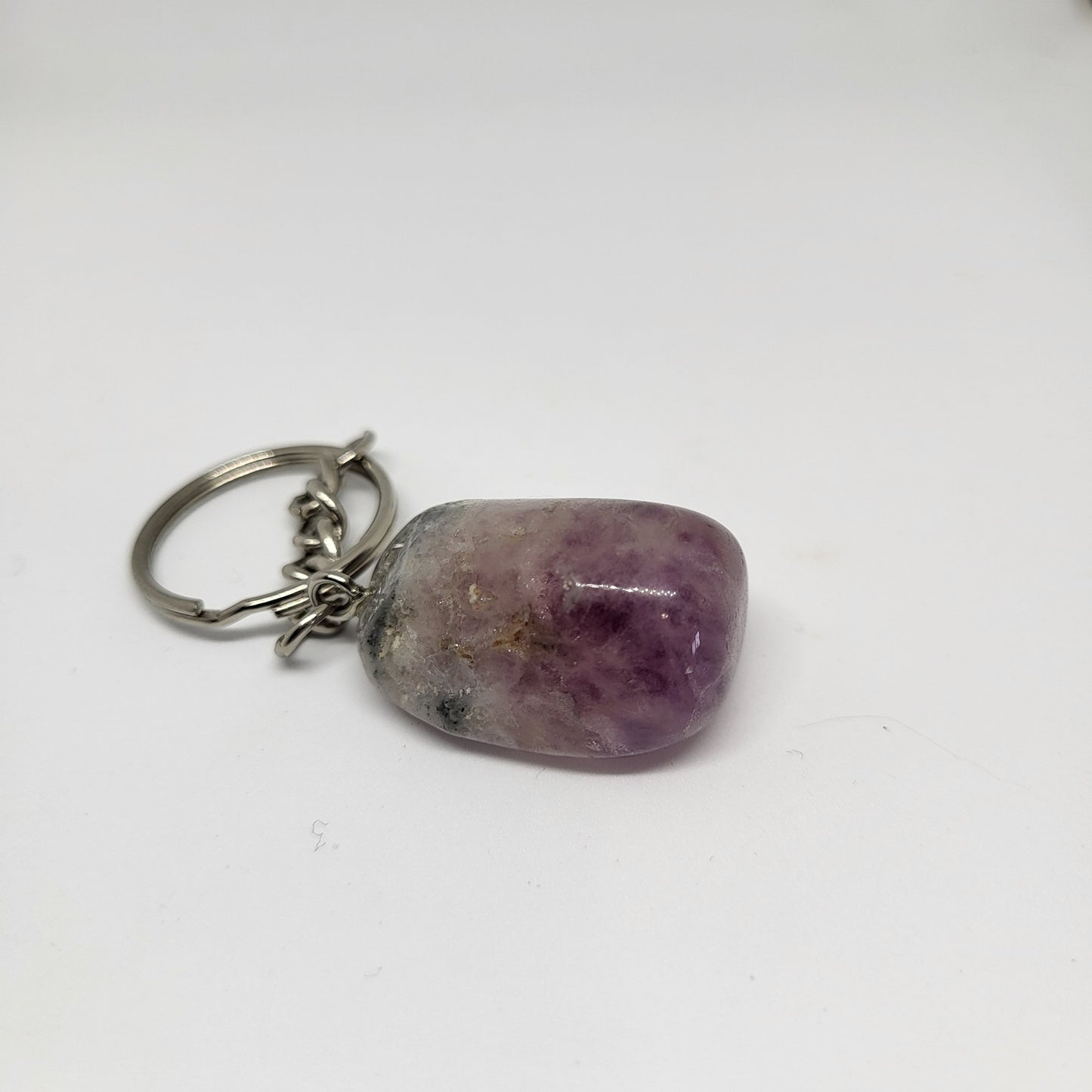 A purple agate crystal keychain against a white background