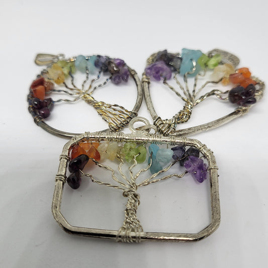 A pendant featuring a silver wire Tree of Life design with multiple colorful gemstones on its branches.