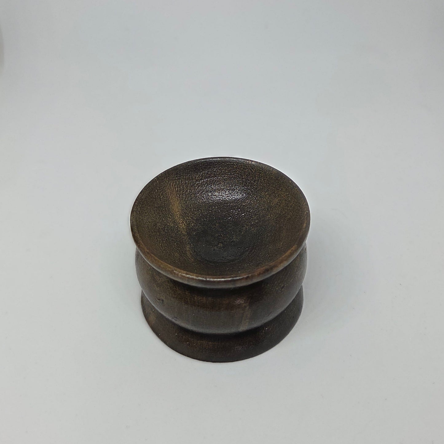 Stack of dark ceramic bowls on a light gray background