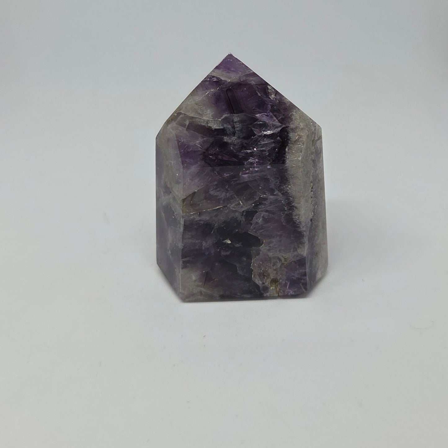 Crystal tower with purple and gray hues on a white background