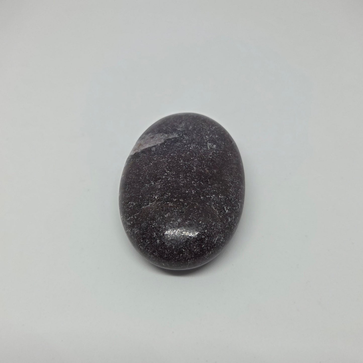Oval-shaped black stone on a gray background