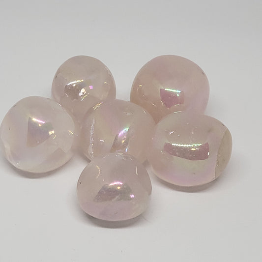A collection of polished aura rose quartz stones with a pink hue and an iridescent shine.