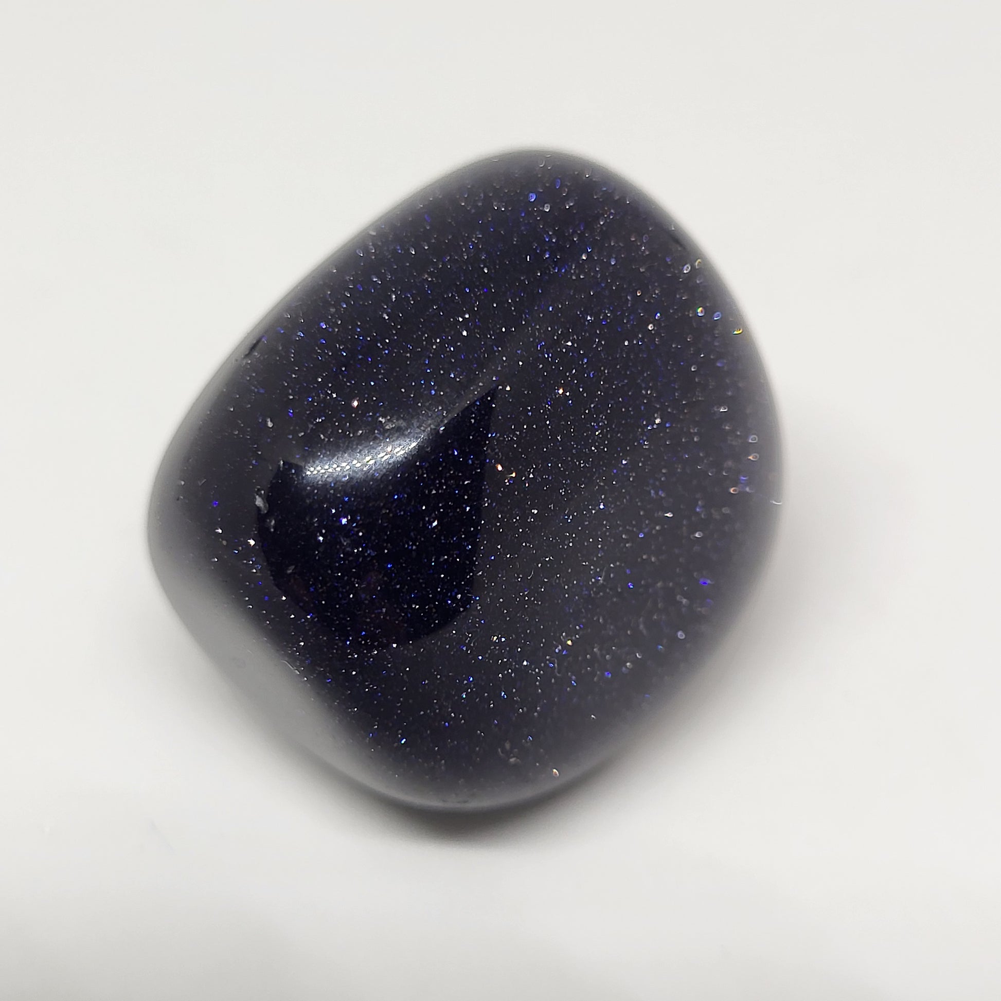 A polished Blue Goldstone gemstone with a sparkling appearance