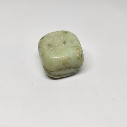 A polished chrysoprase stone with a pale green color