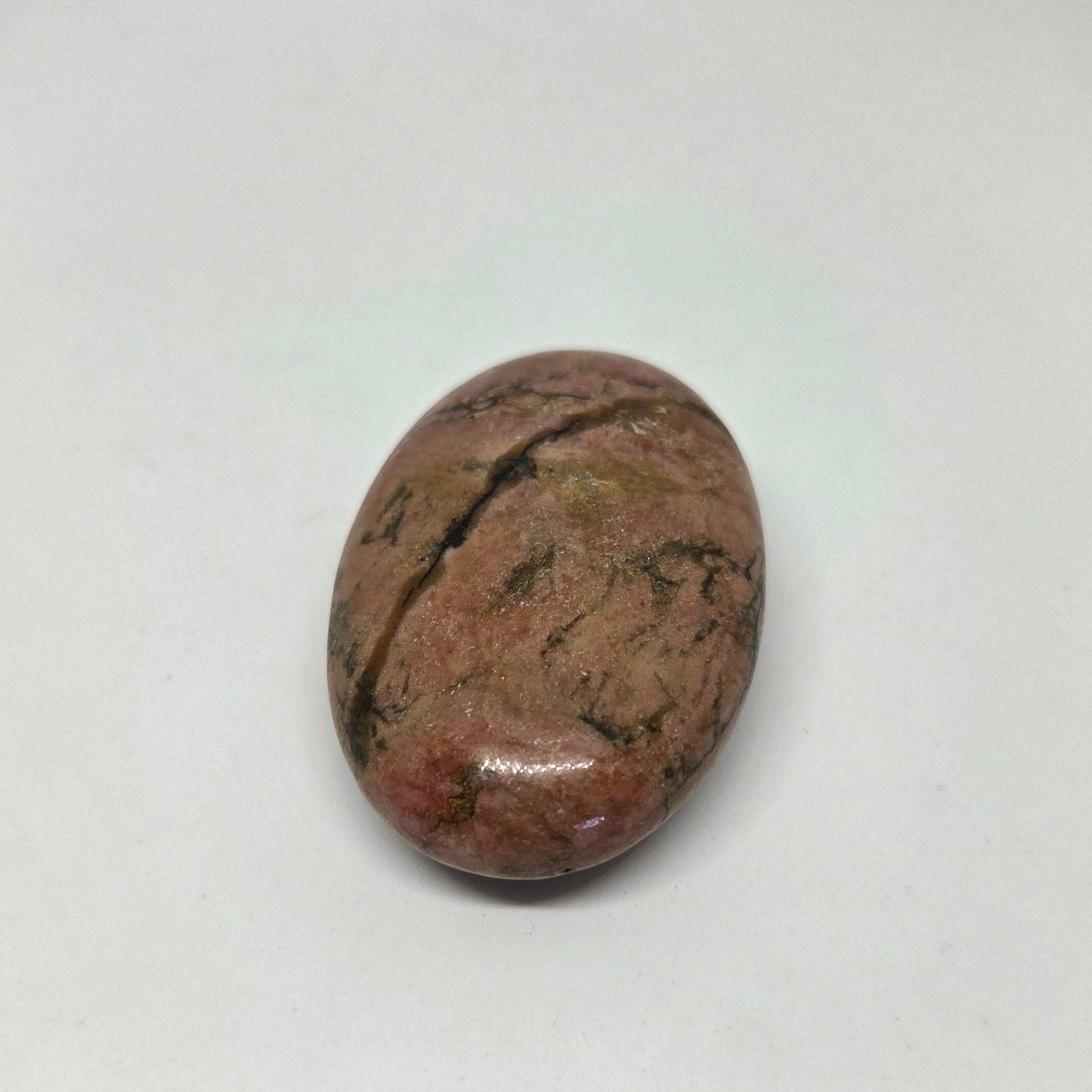 Oval-shaped brown stone with black markings on a white background