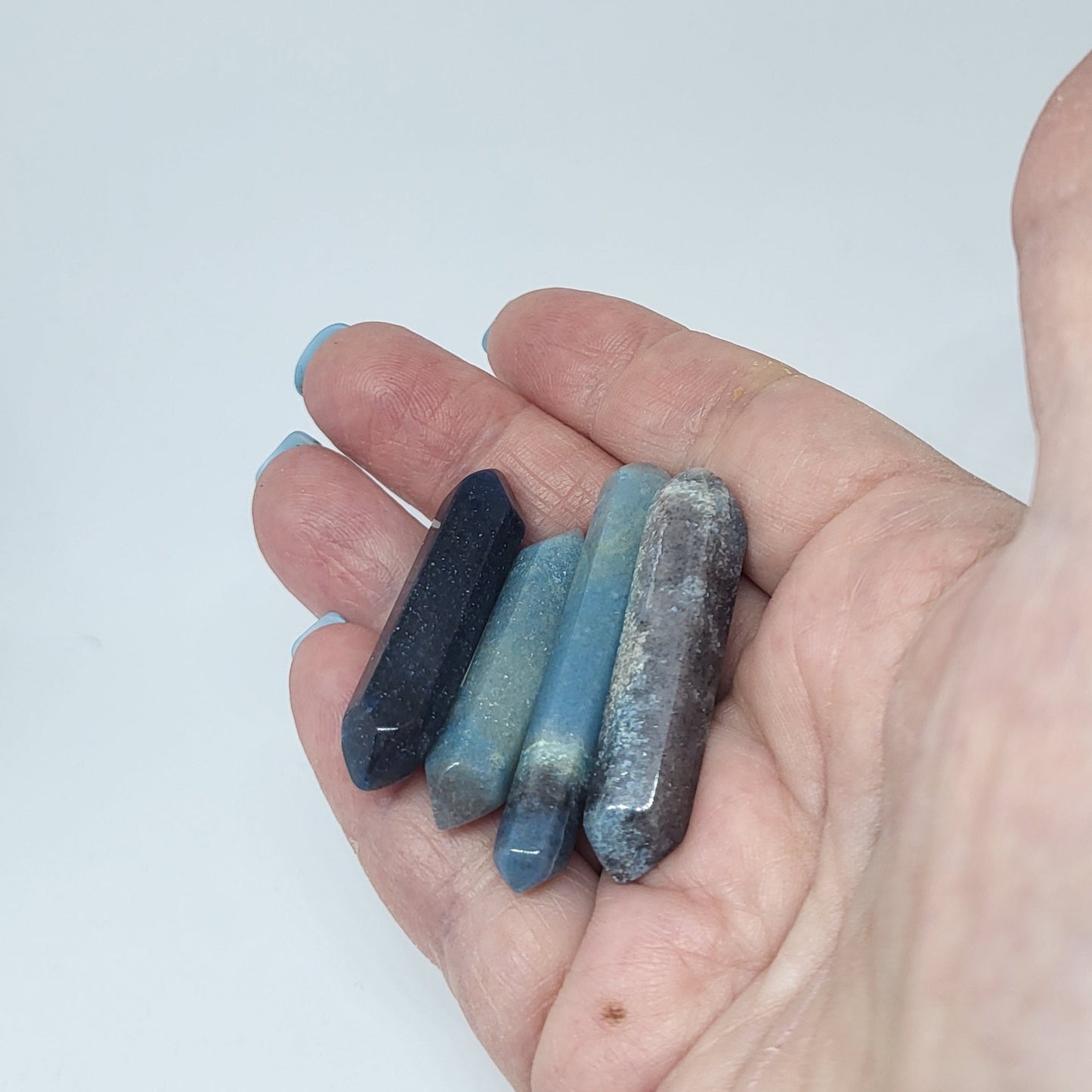Trollite Crystal Energy Pillar in various shades of blue and gray held in hand