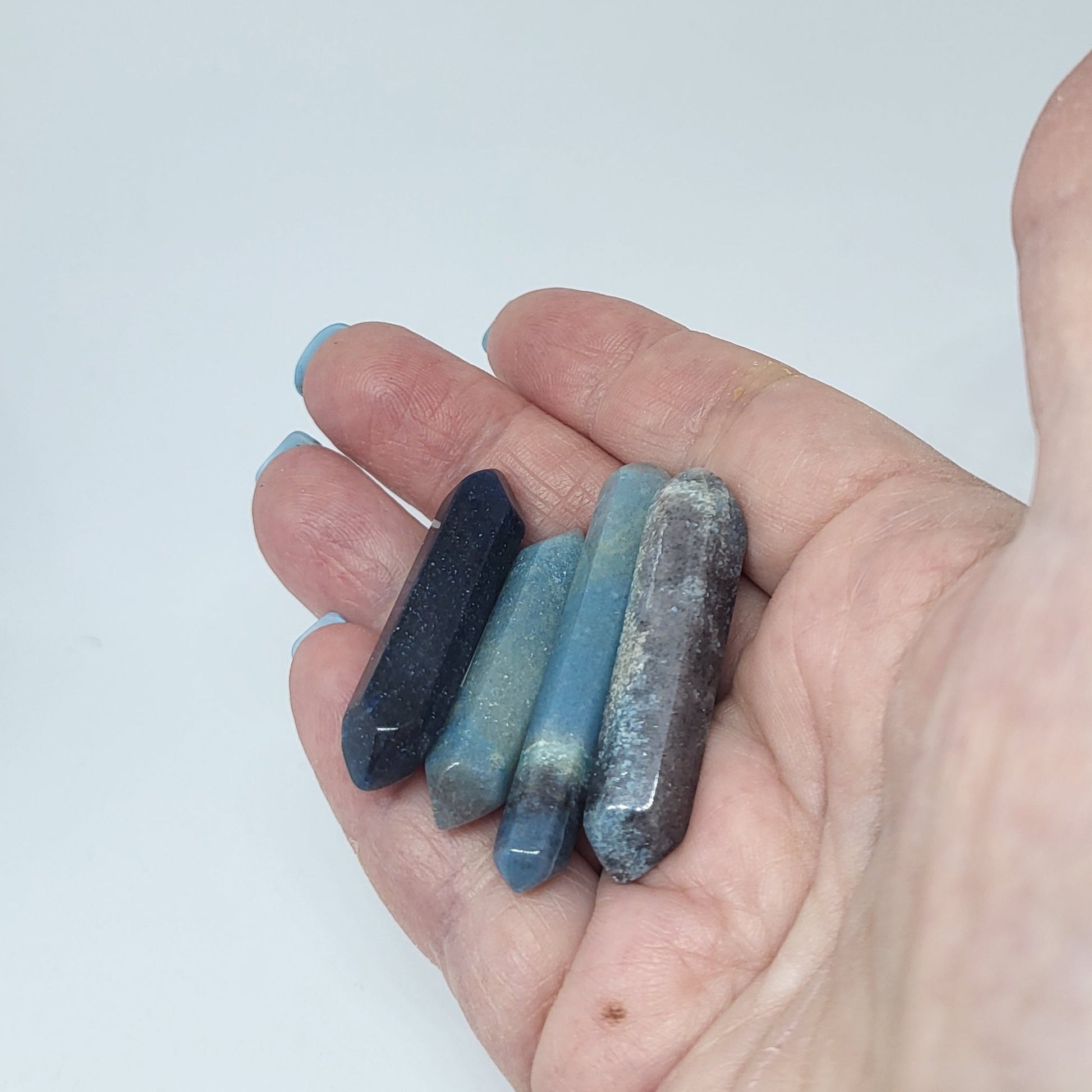Trollite Crystal Energy Pillar in various shades of blue and gray held in hand