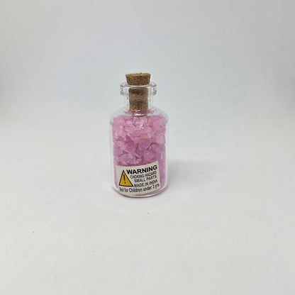 Small glass bottle with pink contents on a white background