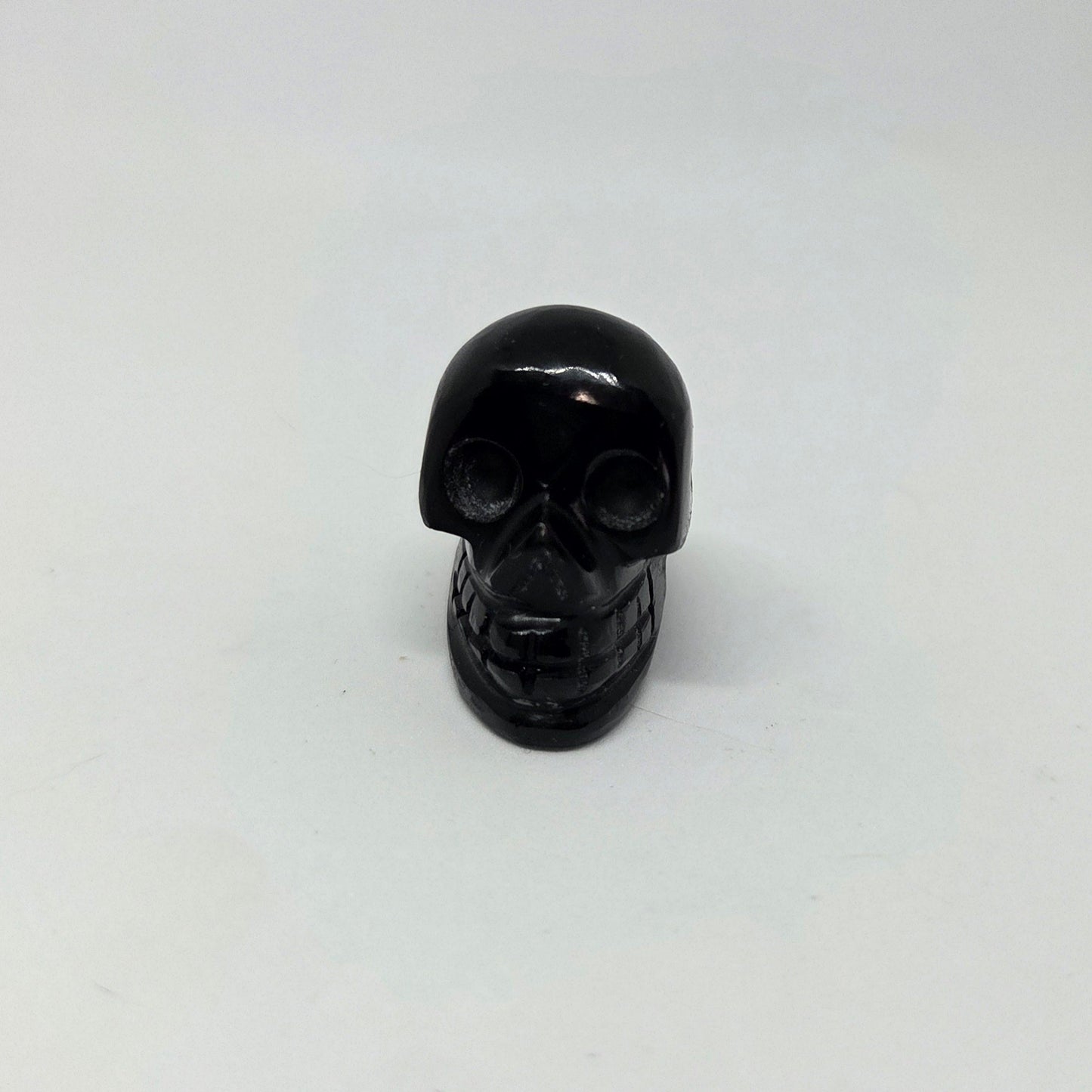 Black skull-shaped object on a white background