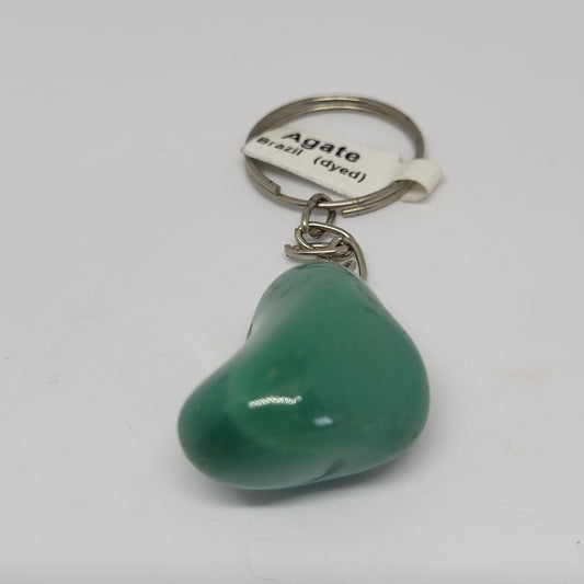 A green dyed agate keychain with a label indicating it is from Brazil, attached to a metal keyring.