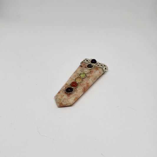 A Sunstone Chakra Pendant with a silver plated top and multicolored gemstones aligned vertically on the front.