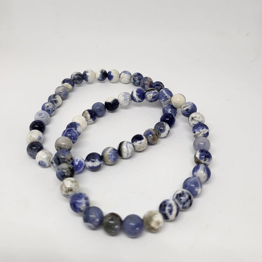 A blue and white sodalite bracelet with 8mm beads, displayed against a white background.