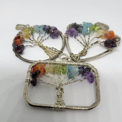 A pendant featuring a silver wire Tree of Life design with multiple colorful gemstones on its branches.