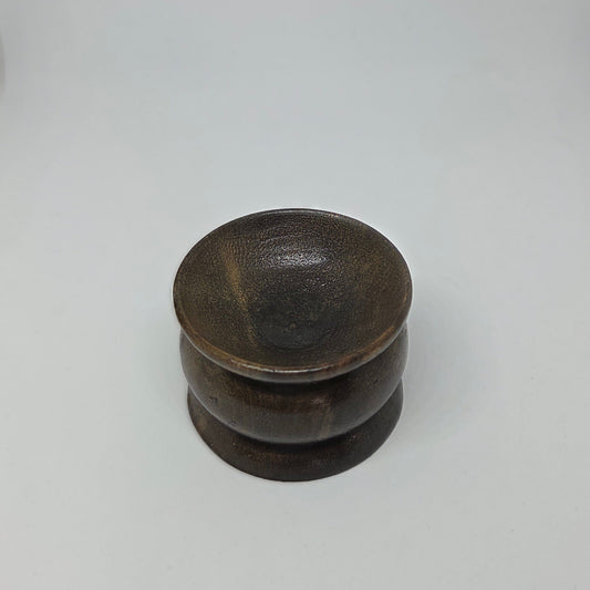 Stack of dark ceramic bowls on a light gray background