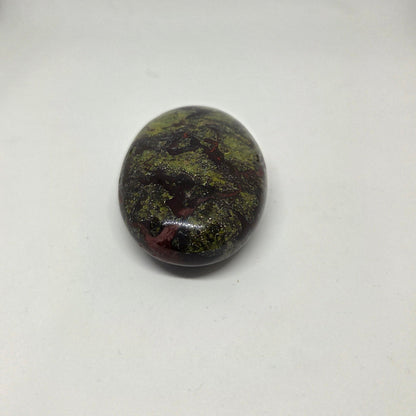 Oval-shaped stone with green and brown patterns on a white background