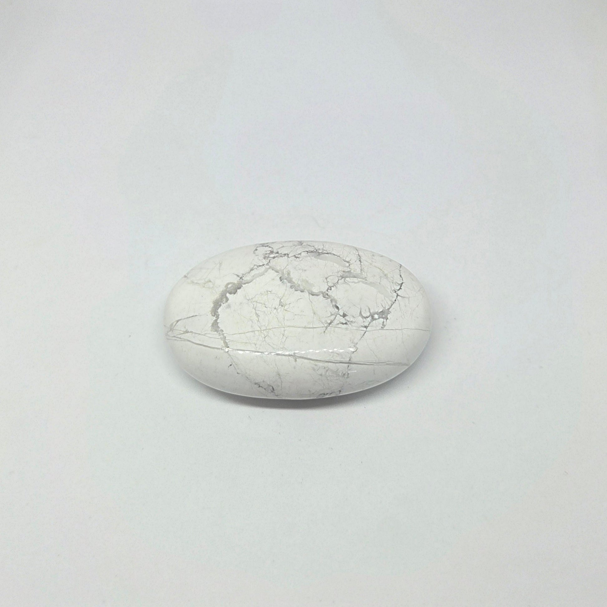 Round white stone with a cracked texture on a light gray background