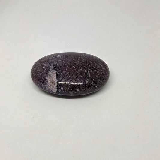 Polished purple stone on a light gray background