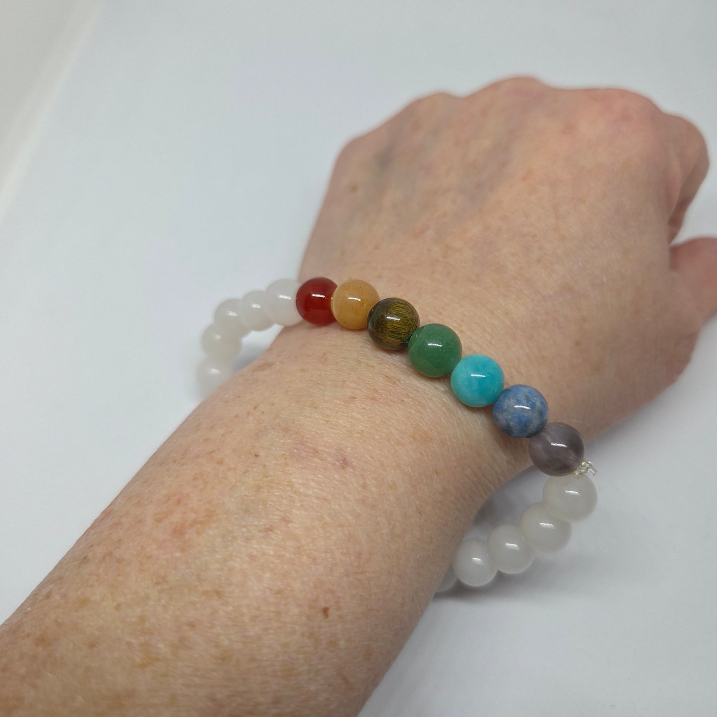 7 Chakra Bracelet with White Base Beads Worn on Wrist