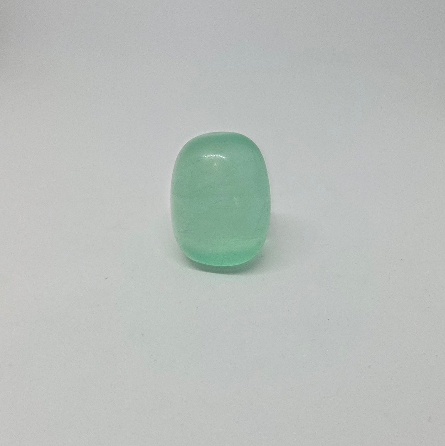 Green fluorite healing tumble, standing upright.